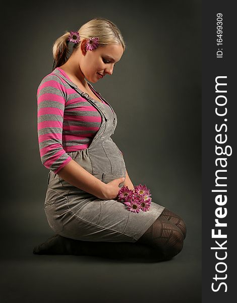 Pregnant young woman on dark background. Pregnant young woman on dark background