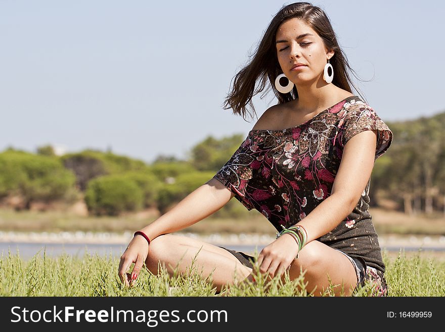 Beautiful girl with floral dress meditating on the nature. Beautiful girl with floral dress meditating on the nature.