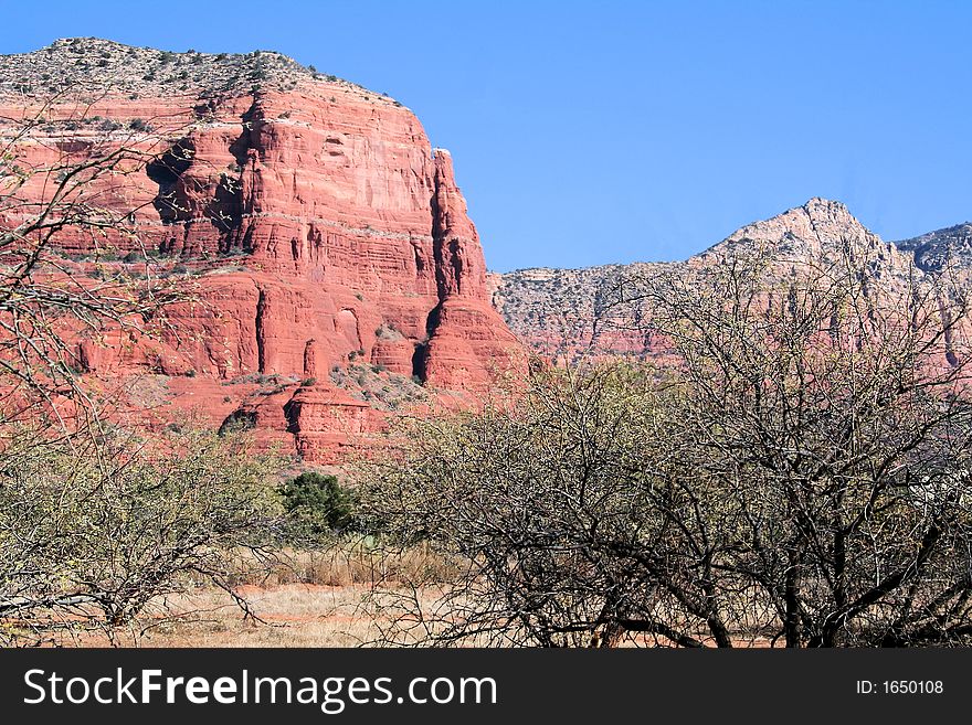 A red rock mountain in Sedona Arizona in the fall. Blue skies, lots of reds blues, yellows and greens. A red rock mountain in Sedona Arizona in the fall. Blue skies, lots of reds blues, yellows and greens