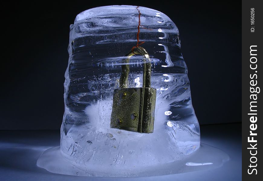 Padlock frozen inside lump of ice. Padlock frozen inside lump of ice