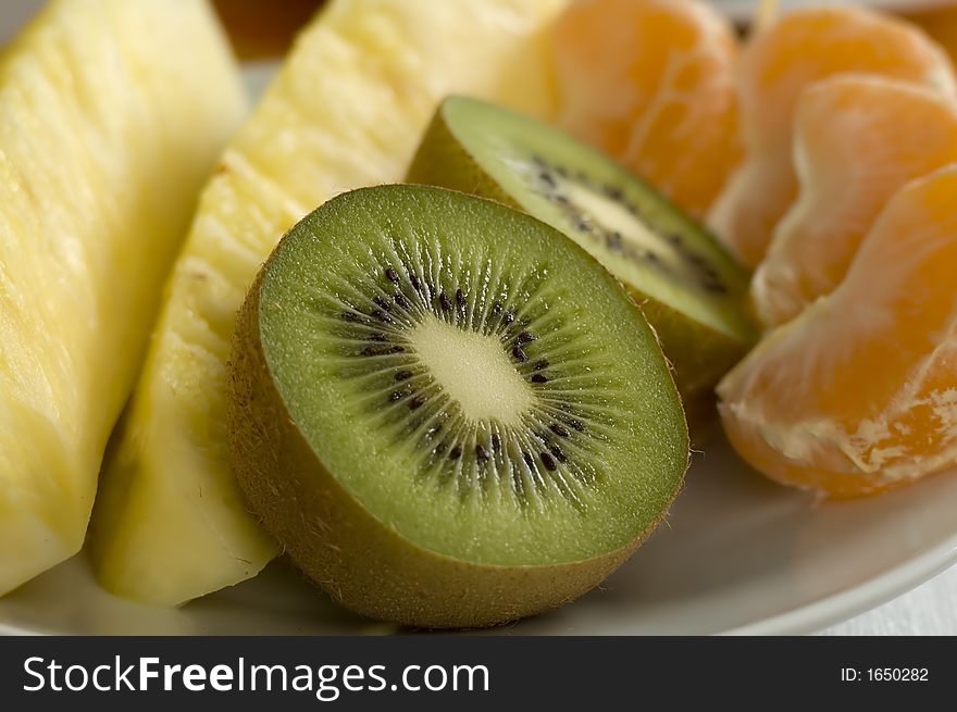 Fresh fruits kiwi, pineapple and mandarin close up