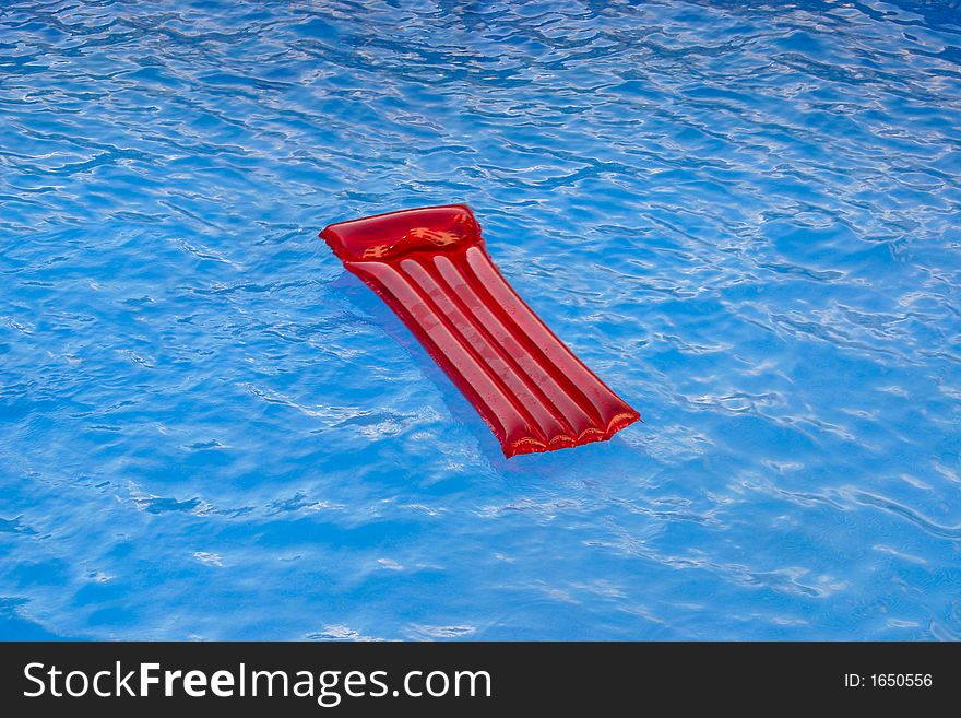 Red lilo on a swimming pool. Red lilo on a swimming pool