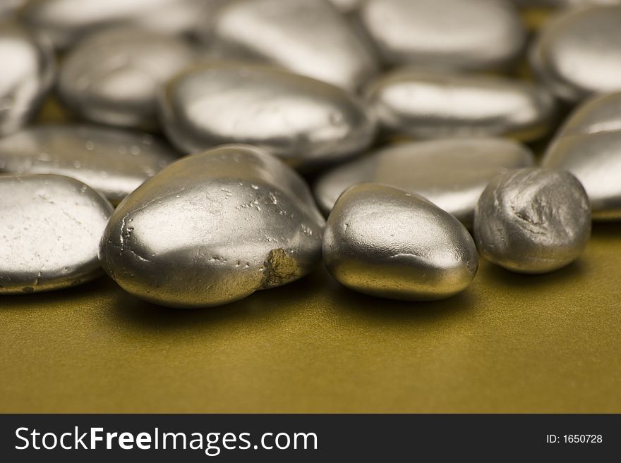 Silver painted stones set against a gold background.