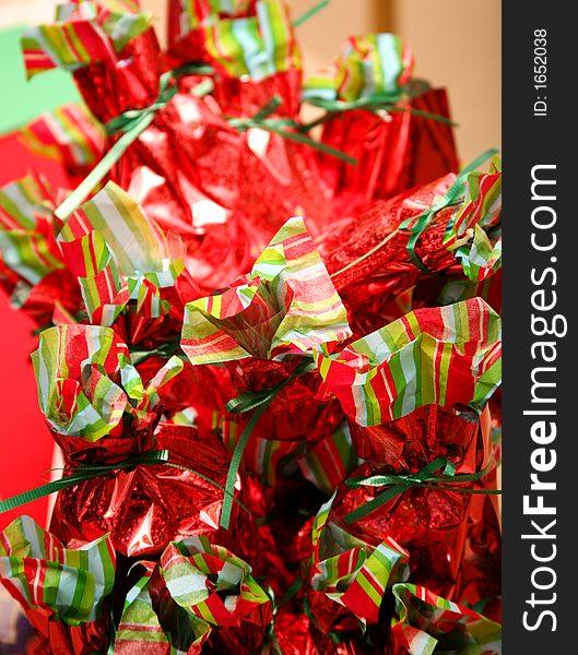 Stack of multiple similar christmas presents on bags of multiple colors