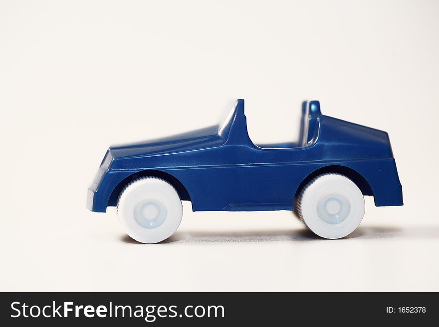 A blue plastic car and a white background