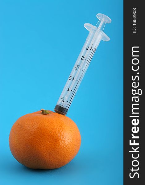 Extracting Juice from a mandarin using a small syringe.