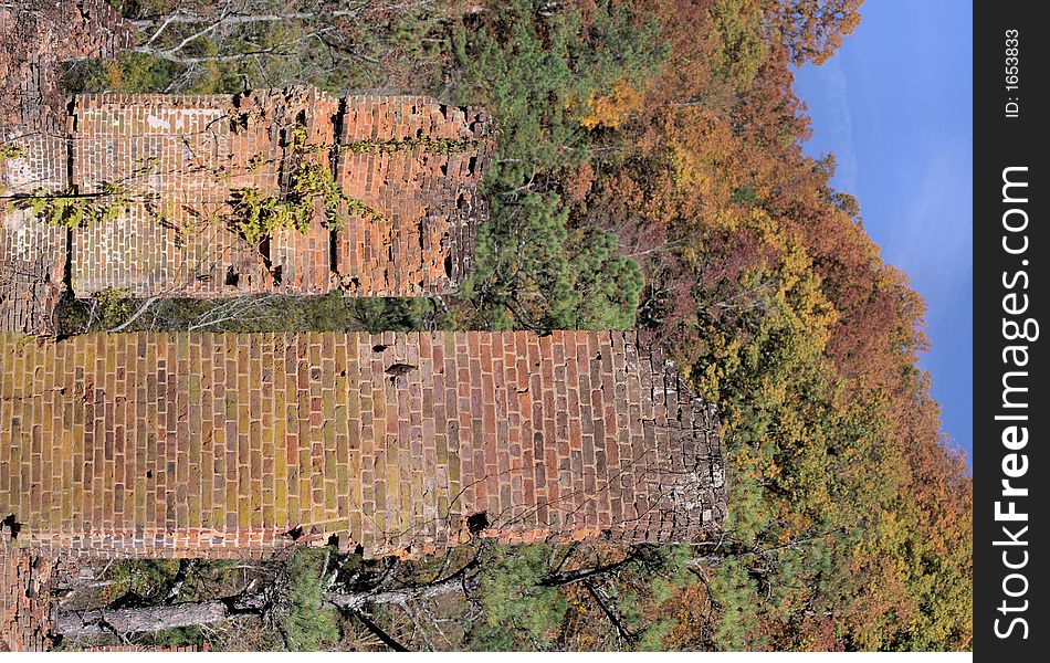 Old grist mill ruins from the civil war era with an autumn background.  If you look closely you can see buckshot holes near the bottom of the columns from a civil war battle. Old grist mill ruins from the civil war era with an autumn background.  If you look closely you can see buckshot holes near the bottom of the columns from a civil war battle.