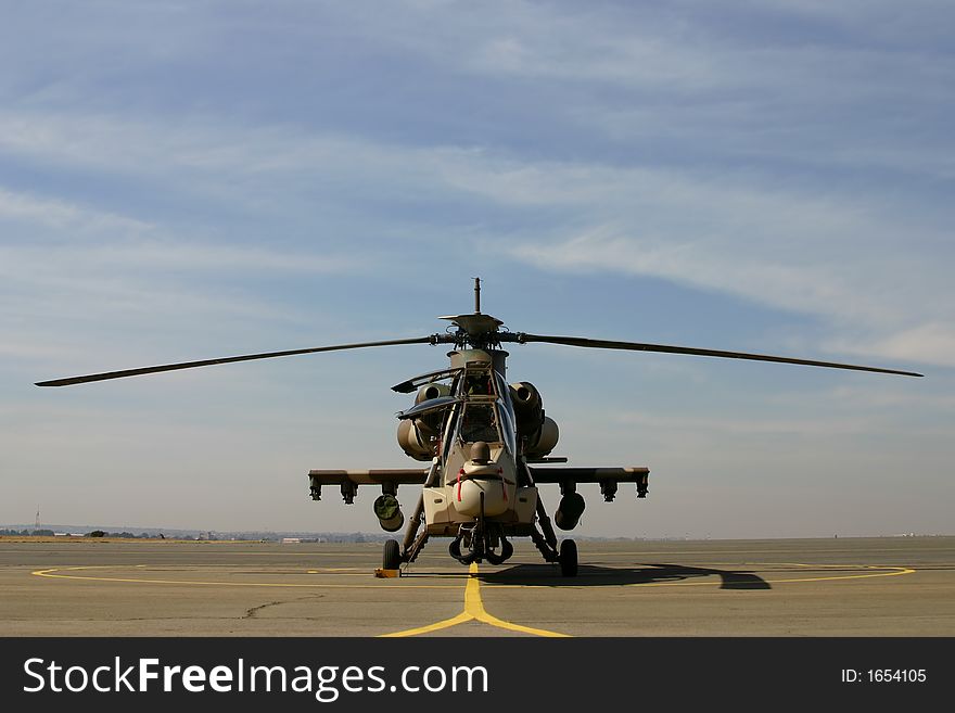 Rooivalk helicopter pre-flight standing on apron with cloudy background. Rooivalk helicopter pre-flight standing on apron with cloudy background