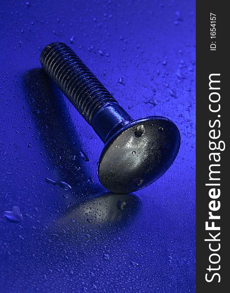 Screw or bolt with metal reflection and water droplets. Screw or bolt with metal reflection and water droplets