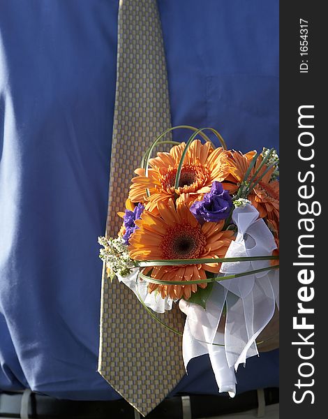 A man waring a tie and shirt is holding the brides bouquet. A man waring a tie and shirt is holding the brides bouquet