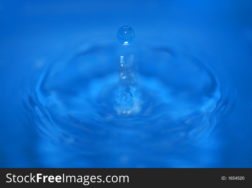 A waterdrop falling in blue water