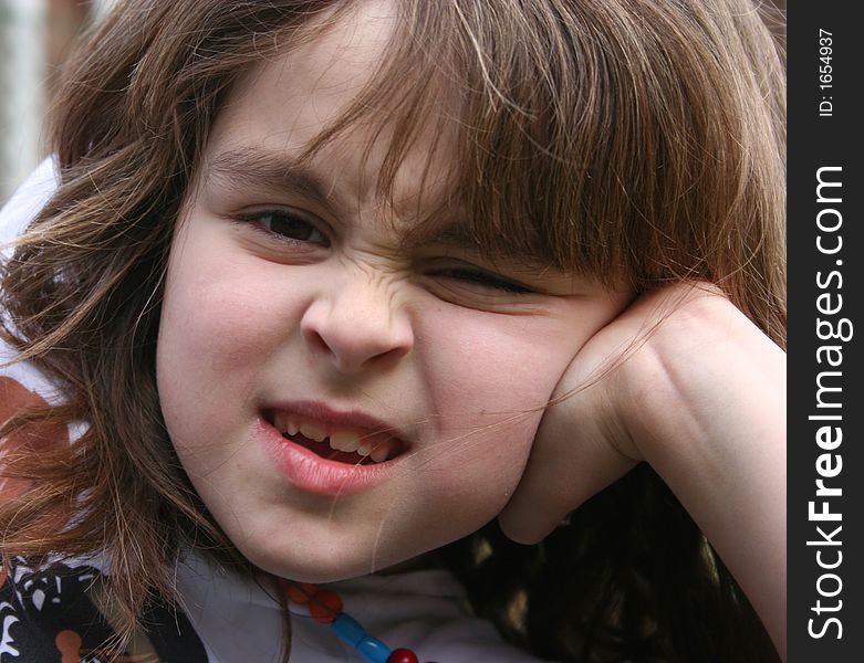 Young girl pulling faces during a photo session, cropped due to possible tshirt copyright. Young girl pulling faces during a photo session, cropped due to possible tshirt copyright