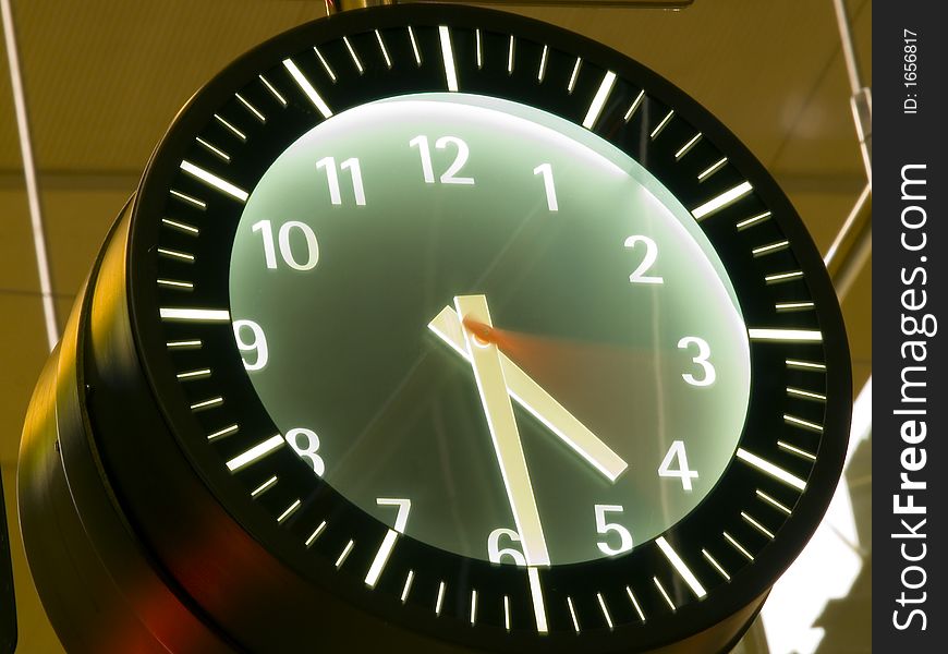 Time passing by in a wall clock with blurred seconds hand