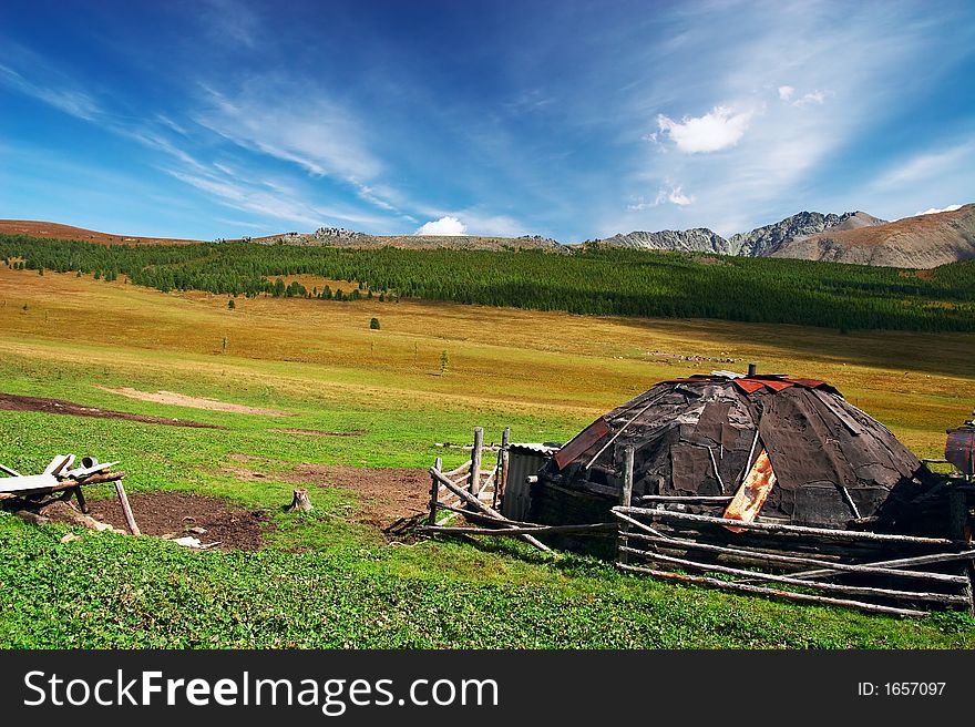 Old house, blue sky and mountains.