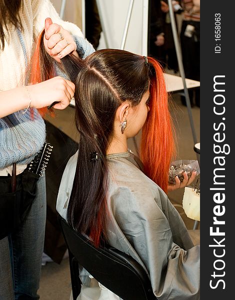 Woman coiffure. Hairdresser does young girl a hairstyle.