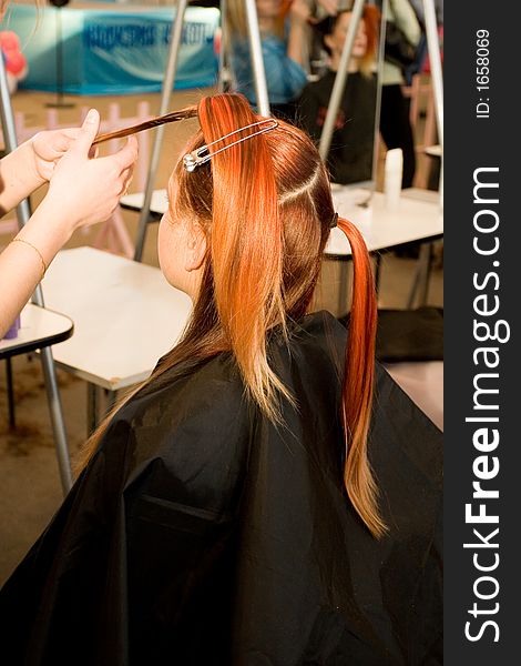 Woman coiffure. Hairdresser does young girl a hairstyle.