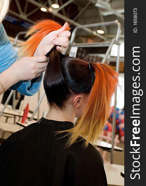 Woman coiffure. Hairdresser does young girl a hairstyle.