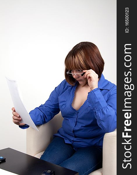 The young woman attentively studies the contract, on a white background