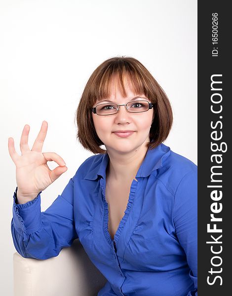 The young woman shows a sign on Ok, On a white background