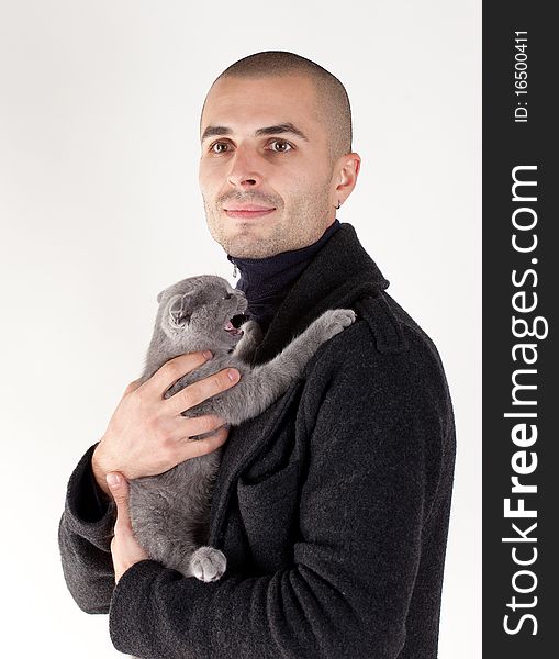 Young man with a small kitten on a white background. Young man with a small kitten on a white background