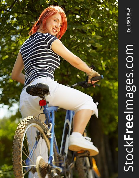 Young Adult Smiling Biker Woman On Mounting Bike