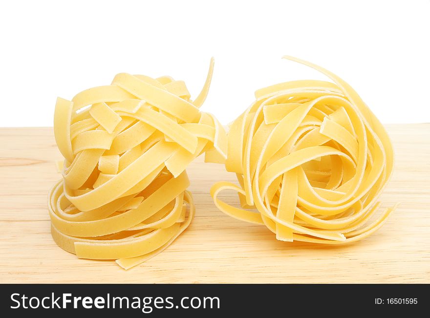 Tagliatelle pasta on a wooden food preparation board
