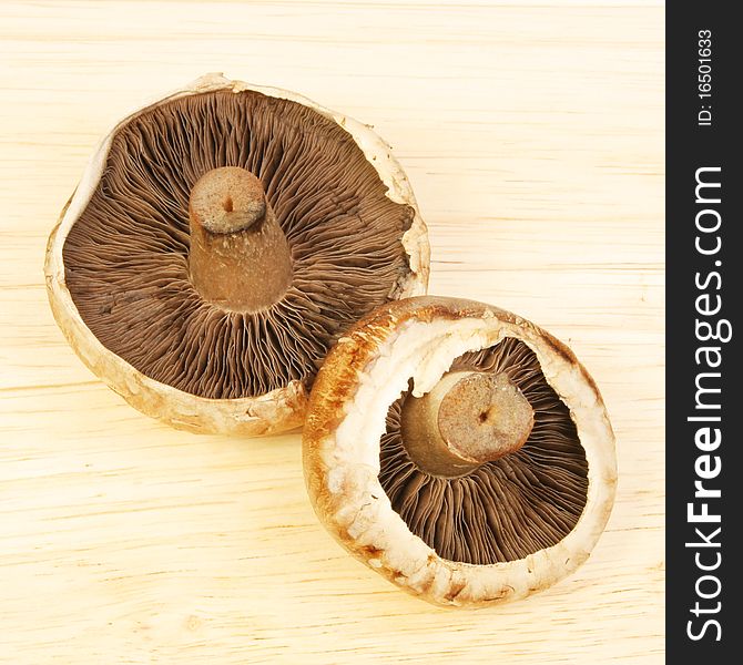 Two portobello mushrooms on a wooden board
