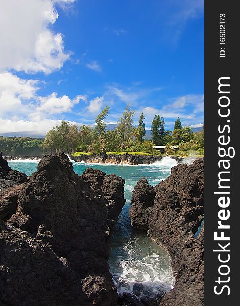 Rocky coastline with waves breaking on rocks. Tropical Island in Caribbean Sea.