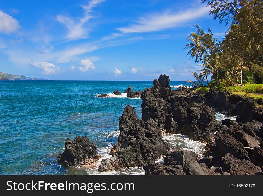 Rocky coastline with waves breaking on rocks. Tropical Island in Caribbean Sea.