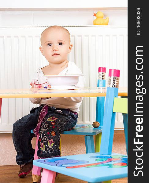 Little girl at the table in the kitchen. Little girl at the table in the kitchen.