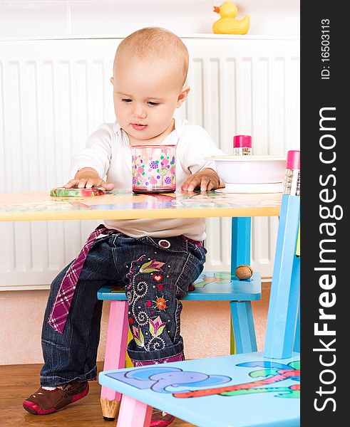 Beautiful baby girl sitting at the table