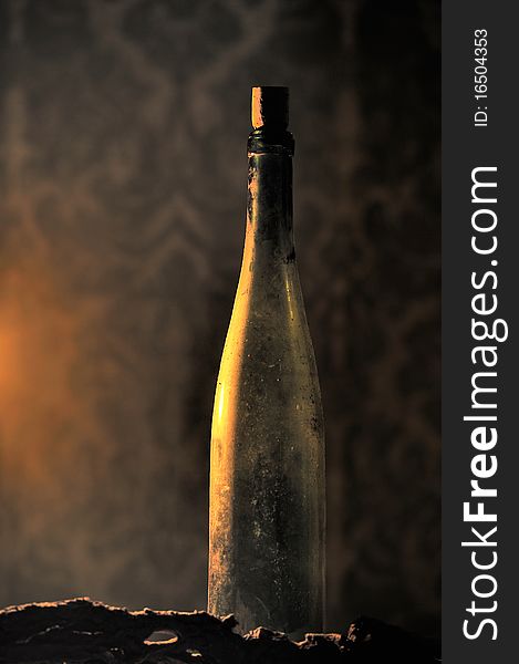 Side view of a candle lighted bottle of wine with blurry background