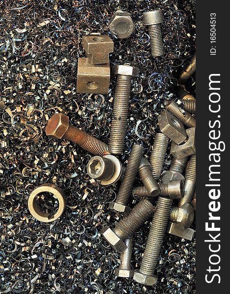 Steel screws, female screws and steel-wool in a metalworking yard