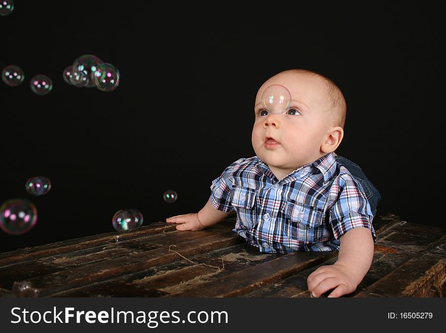 Cute little boy on an antique trunk wearing blue jeans. Cute little boy on an antique trunk wearing blue jeans