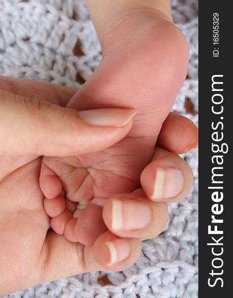 Mother holding foot of a newborn baby. Focus on wrinkles on Foot. Mother holding foot of a newborn baby. Focus on wrinkles on Foot.