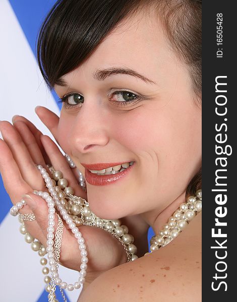 Beautiful brunette female holding pearl jewellery against Scottish flag. Beautiful brunette female holding pearl jewellery against Scottish flag