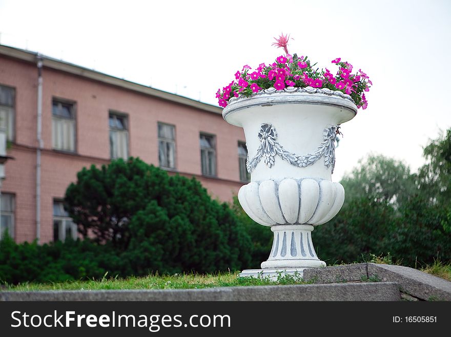 White vase with flowers outside in the park