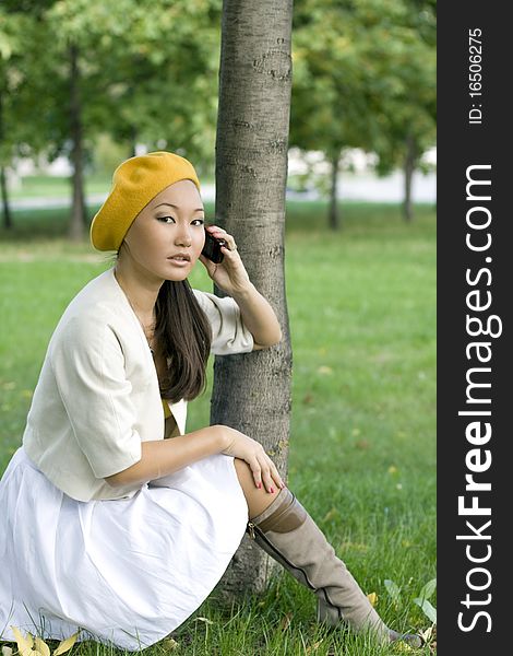 Girl talking by phone in autumn park