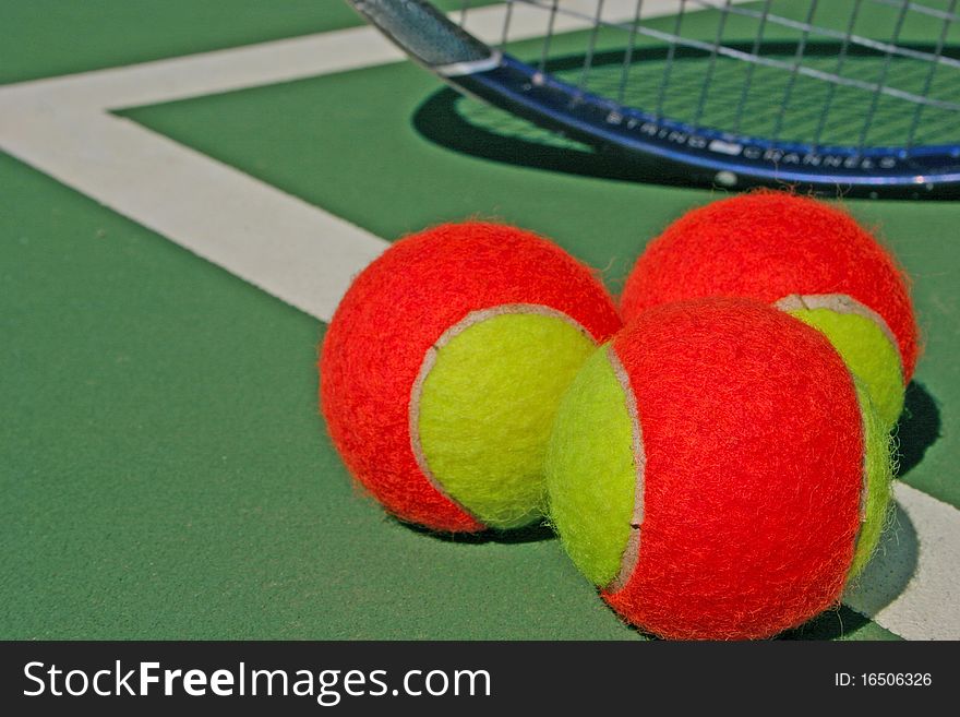Three tennis balls and a racket