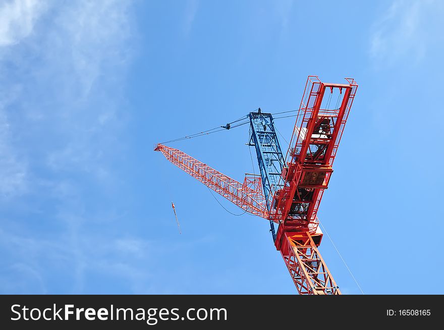 Red crane on blue sky background. There is a huge development in Downtown Toronto, Canada