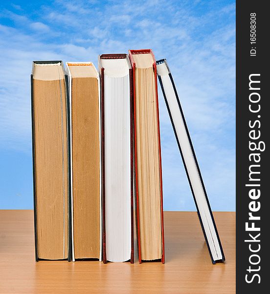 Row of books on sky background