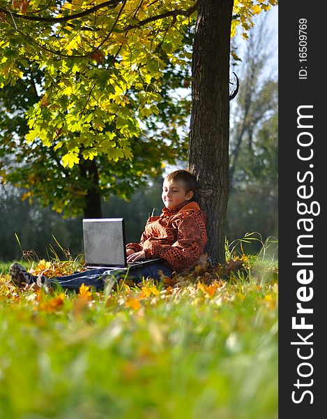 Child make fun with notebook under tree in autumn forest. Child make fun with notebook under tree in autumn forest