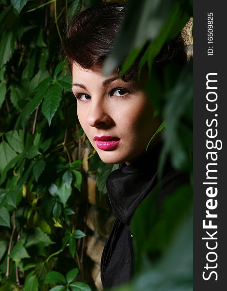 Young and attractive lady beside with brick wall, overgrown of vine leaves. Young and attractive lady beside with brick wall, overgrown of vine leaves