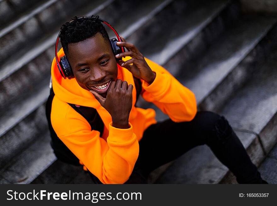 African-american man in wireless headphones listening music