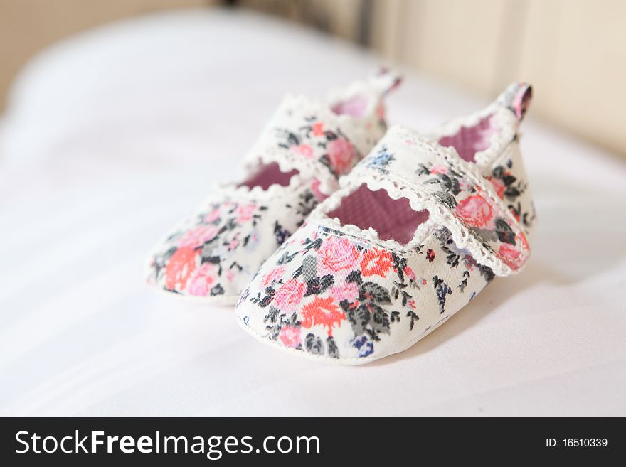 Hand made baby bootees standing on the pillow. Hand made baby bootees standing on the pillow