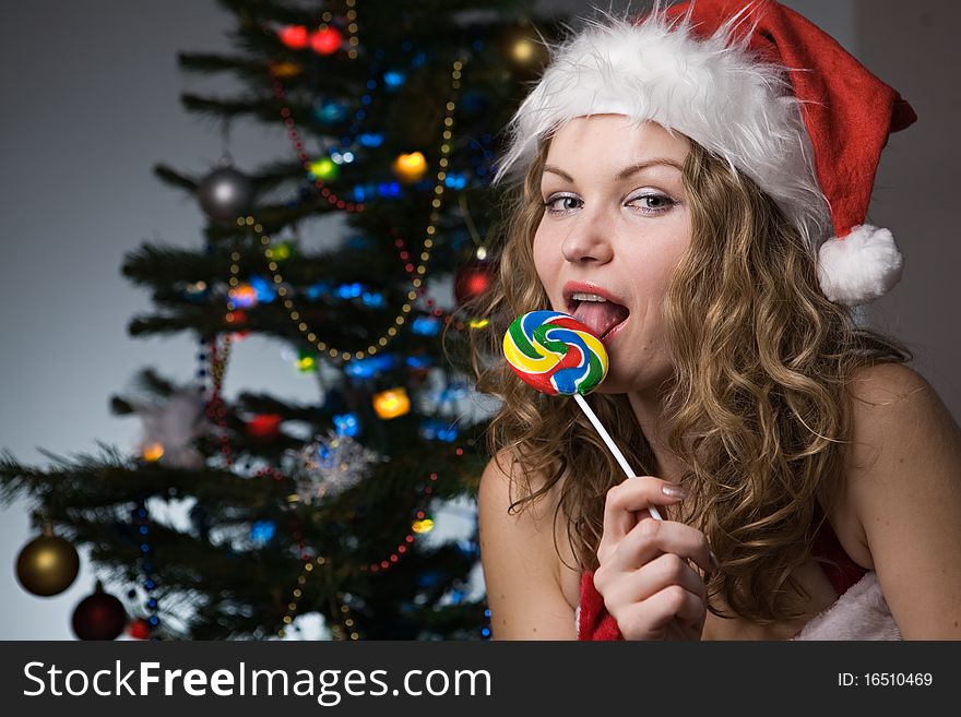 Beauty woman in santa hat wih christmas tree