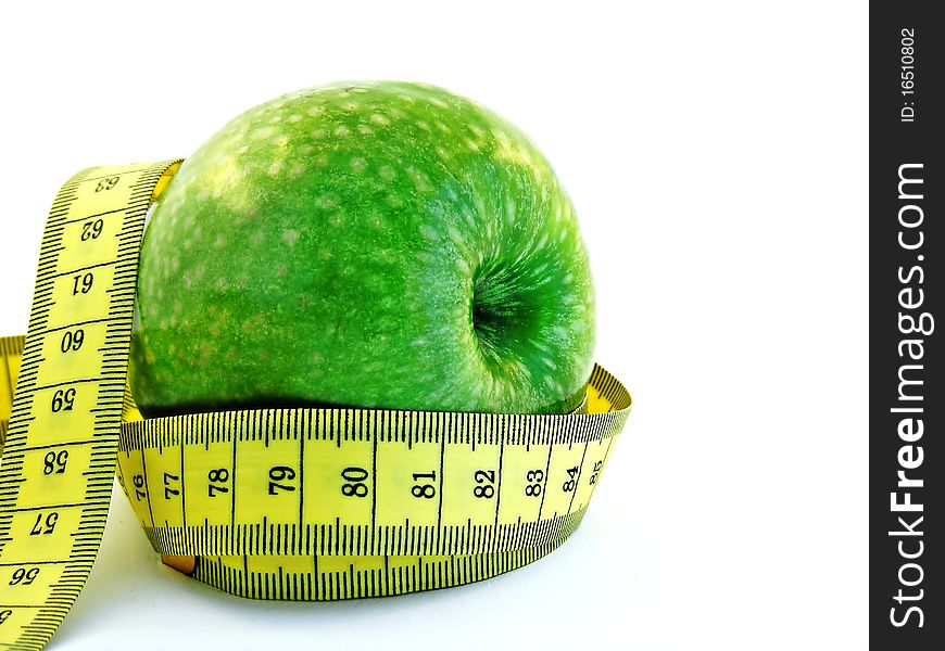A fresh green apple with a yellow measuring tape on a white background. A fresh green apple with a yellow measuring tape on a white background