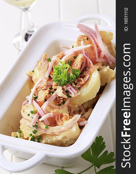 Potato salad sprinkled with chives and ham