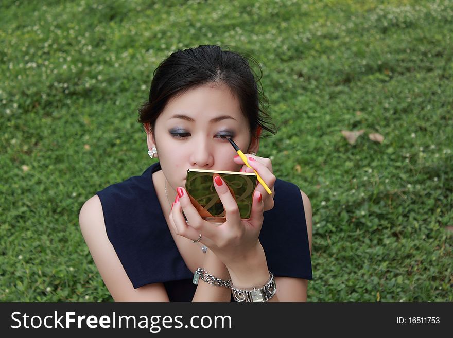 Beautiful woman applying colorful eye makeup. Beautiful woman applying colorful eye makeup