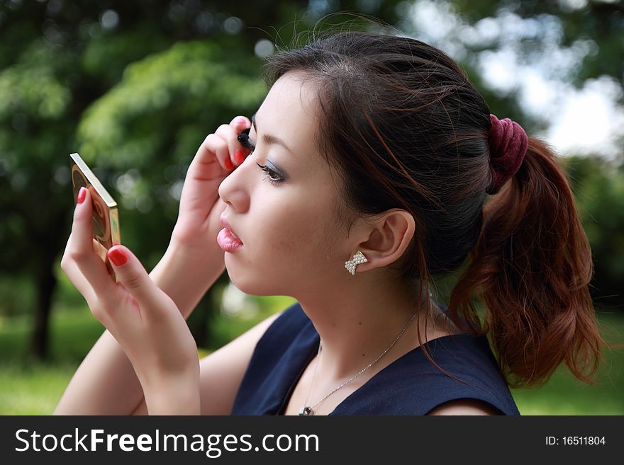 Beautiful woman applying colorful eye makeup. Beautiful woman applying colorful eye makeup
